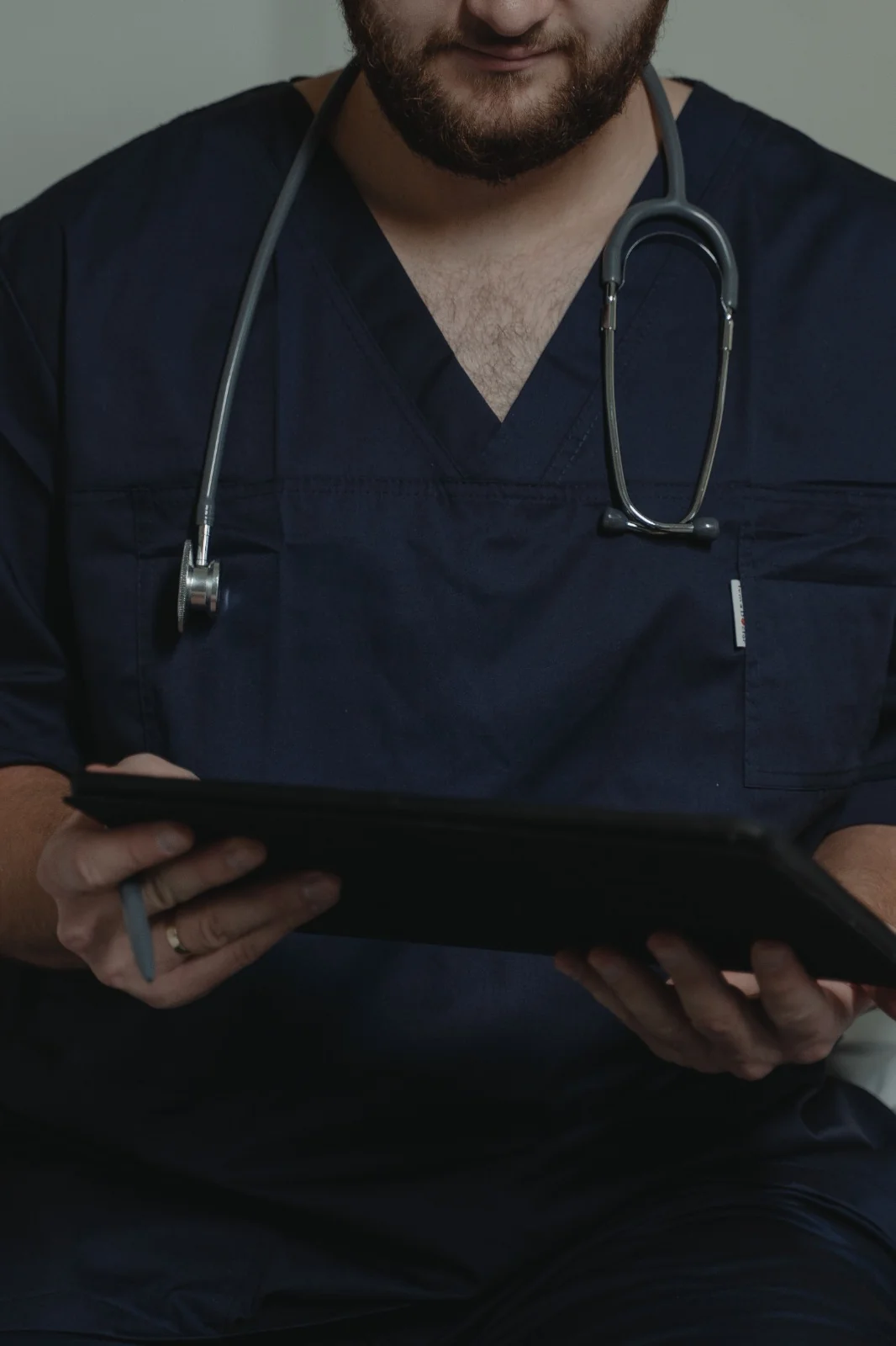 Clinician in scrubs using a tablet for digital healthcare work